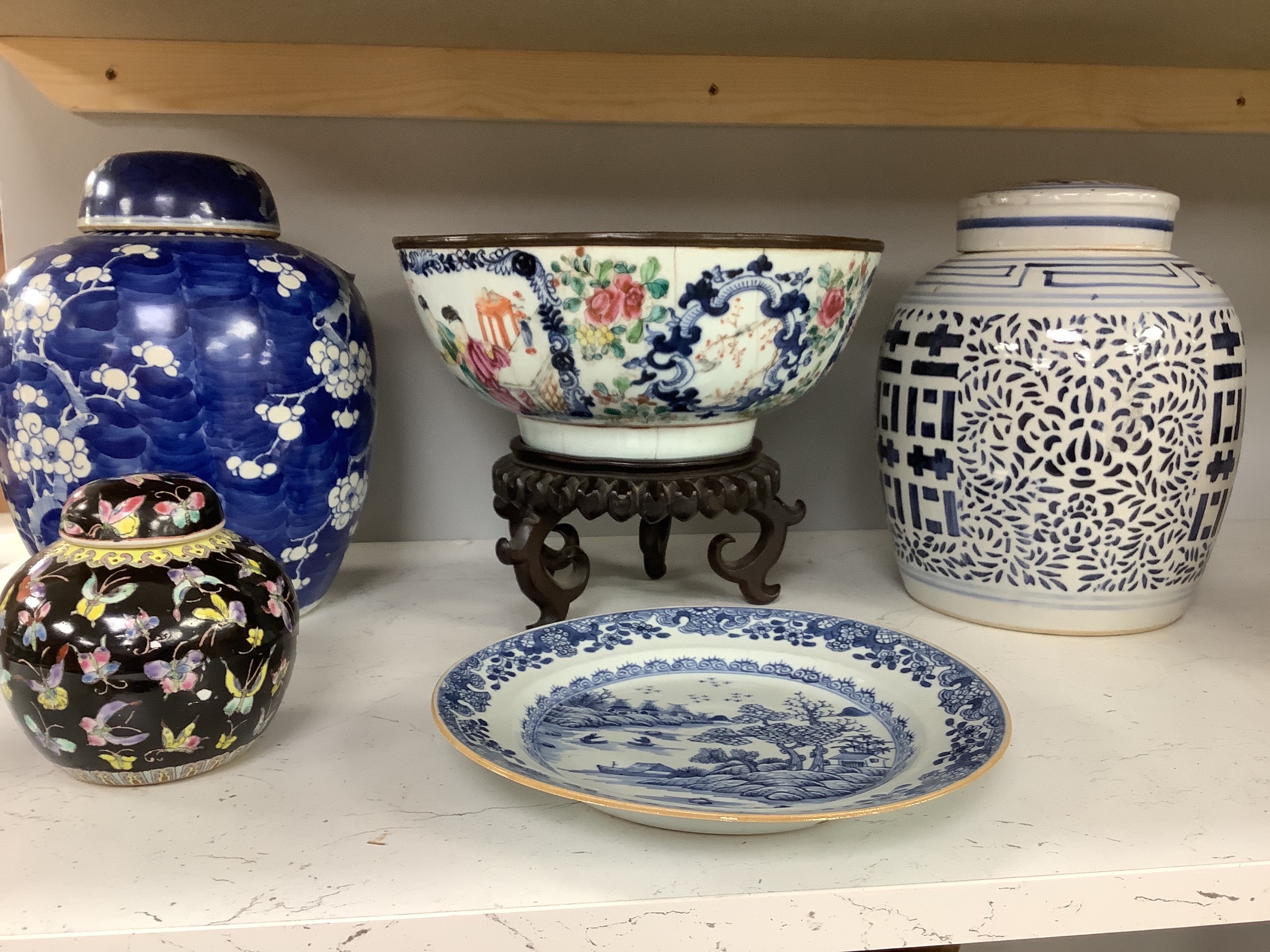 A 19th century Chinese porcelain prunus jar and cover, 27cm, on carved wood stand, a smaller famille noire jar and cover, a Chinese export fruit bowl, blue and white dish and a similar jar and cover 27cm